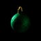 Green Christmas bauble over dark background. Low key photo. Ball shape.