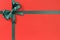 Green Christmas gift ribbon bow on plain red background paper, copy space