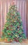 Green Christmas tree with many vibrant colored ornaments, colored lights, decorated, close up, indoor, Christmas spirit