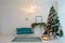 Green Christmas tree with a pink decor. Turquoise couch in the i