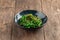 Green chuka seaweed salad in a black bowl