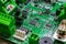 Green circuitboard with microcontroller in centre of small city