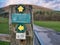 Green circular waymarkers fixed to a weathered wooden post near Dunsop Bridge in Lancashire, UK.