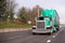 Green classic big rig semi truck with long covered semi trailer