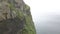 Green cliffs of farroe islands in cloudy weather