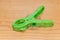 Green clothespin on wood background