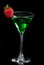 Green cocktail absinth decorated with red strawberry in martini