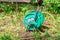 Green coil for watering with yellow hose on the lawn on a Sunny day