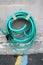 Green Coiled Hose Hung On Cement Wall