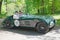 Green color HRG Aerodynamic classic car from 1947 driving on a country road