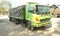 Green colored flatbed heavy trucks used to transport and distribute cements sacks from factory to points of sales or distributors