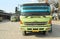 Green colored flatbed heavy trucks used to transport and distribute cements sacks from factory to points of sales or distributors