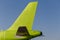 Green colored tail of commercial jet aircraft, blue sky as background. Airplane`s fuselage. Aviation and transportation. Isolated