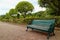 Green Colored Wood and Wrought Iron Bench on the Pathway in Public Garden