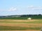 Green combine tractor harvesting oast field