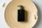 Green cosmetic bottle and dried flowers on plate. SPA natural organic cosmetics for personal hygiene. Soap dispenser or shampoo