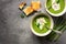 Green cream asparagus soup with crispy toasts on a gray background. Vegan and vegetarian lunch and dinner. Top view, copy space