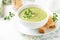 Green cream vegetable soup broccoli, peas, zucchini, spinach) with toast, croutons. Delicious vegetarian healthy spring, summer