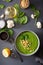 Green creamy cauliflower spinach soup on gray background