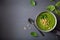 Green creamy cauliflower spinach soup on gray background