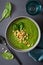 Green creamy cauliflower spinach soup on gray background