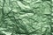 Green creased metallic foil background texture