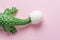 Green crocodile toy with egg shell on pastel pink background. Minimal art concept