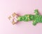 Green crocodile toy with gift box on pastel pink background. Minimal art concept