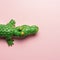 Green crocodile toy on pastel pink background. Minimal art concept