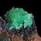 Green crystals of the anapaite mineral on brown iron ore rock