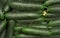 Green cucumbers displayed at food market, detail from above