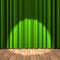 Green curtain stage with a spot light