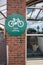 Green cycle parking sign on a wall at shopping centre