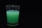 Green detergent liquid glass on a black background