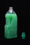 Green detergent liquid plastic bottle on a black background