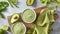 Green detox smoothie with avocado and asparagus in white bowls on the wooden board with green napkin on gray stone