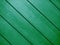 Green diagonal interior design wooden slat wall wood panel designer decor closeup painted background