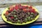 Green dish with red and green castor beans and fruits Ricinus communis L