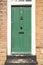 Green Door in a Brick Building