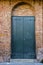 Green doors in brick archway