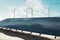 Green energy and alternative source of electricity concept with perspective view on sunlit solar farm on sand and windmills on