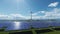 Green energy solar panels and wind turbines against lake and city skyline, tilt from mantenance workers and supervisor, 4K