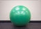 Green exercise ball on an isolated background at the gym