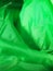 Green fabric, taken close-up, wrinkled, uneven, wavy