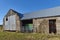 A Green Farm Trailer lies parked within this old Farm Steading, secured only by a simple Farm Gate.