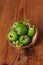Green feijoa in a coconut shell hulf on a wooden background. Ripe tropical fruits, raw vegan food.Vitamin C. Copy space
