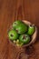 Green feijoa in a coconut shell hulf on a wooden background. Ripe tropical fruits, raw vegan food.Vitamin C. Copy space