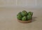 Green feijoa fruits in a cork plate. Tropical fruit feijoa. Set of ripe feijoa fruits. Copy space