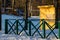 Green fence in winter snowdrifts and yellow house