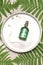 green fern plant branches and female perfume bottle scent, natural oil on plate with accessories, eco organic cosmetics